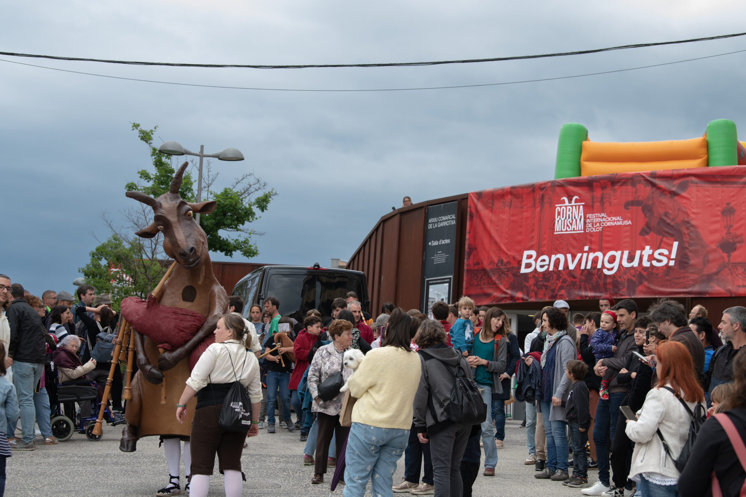 La Cabreta, una pancarta de benvinguda al festival i gent ballant al voltant de la Cabreta.